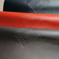 Rolled black and red leather mahjong mats with embossed pattern