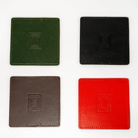 Four square leather mahjong coasters in green, black, brown and red