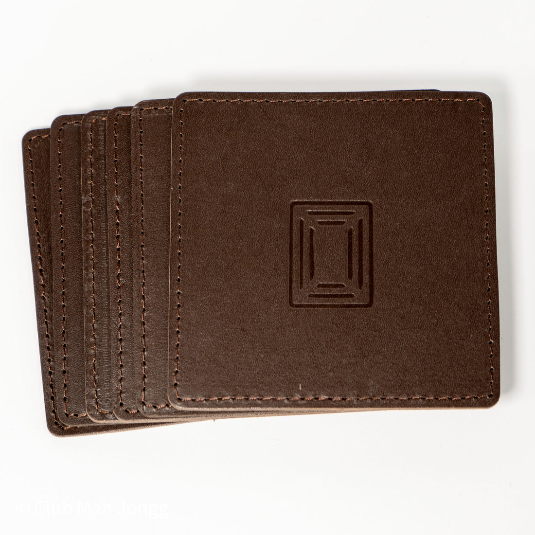 Stack of brown square leather mahjong coasters with embossed Club Mah Jongg icon